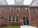 The backyard featuring a brick wall, sliding glass door, and well-maintained lawn offers a private outdoor space at 12032 Lavinia Ln, Charlotte, NC 28277