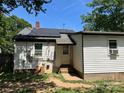 Exterior view of the home's back, featuring solar panels and showing back door at 1212 Meadow Ln, Charlotte, NC 28205