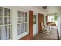 Cozy covered porch with white rocking chairs, a swing, and brick accents providing a relaxing outdoor space at 1233 E Cannon Ave, Albemarle, NC 28001