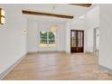 Spacious entryway featuring hardwood floors, wood beams, large windows, and elegant lighting at 124 Clipper Ln, Mooresville, NC 28117