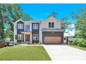 Beautiful modern home with a two-car garage and well-manicured lawn and professional landscaping at 124 Clipper Ln, Mooresville, NC 28117