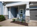 Inviting front porch with rocking chairs, stone accents, and a well-manicured garden at 1260 Thomas Knapp Pkwy, Fort Mill, SC 29715