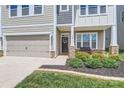 Welcoming home entrance features stone accents, a dark door, and beautiful landscaping at 128 Championship Dr, Mooresville, NC 28115