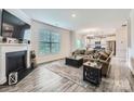 Open concept living room with fireplace, wood floors, and seamless flow to the modern kitchen at 128 Championship Dr, Mooresville, NC 28115