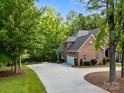 Elegant brick home featuring an attached garage and a long driveway surrounded by mature trees at 130 Churchill Dr, Salisbury, NC 28144