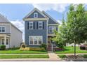 Charming two-story home featuring well-manicured lawn, lush greenery, and inviting front porch at 13714 Jacks Ln, Pineville, NC 28134