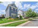 A street view of a two-story home featuring well-manicured lawn and lush landscaping at 13714 Jacks Ln, Pineville, NC 28134