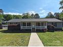 Inviting single-story home featuring a classic front porch and walkway through the green front lawn at 1495 Carson Rd, Cleveland, NC 27013