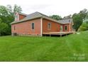 A view of a home featuring shingle siding, with a large wooden deck and grassy yard at 15027 Beatties Ford Rd, Huntersville, NC 28078