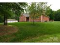 A view of a home with shingle siding, 3-car garage, and lush green yard at 15027 Beatties Ford Rd, Huntersville, NC 28078