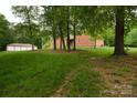 Spacious backyard with lush greenery, a garage and view of the home, perfect for outdoor activities at 15027 Beatties Ford Rd, Huntersville, NC 28078