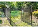 Open metal gate into a fenced community dog park, with lush green grass at 1512 Seigle Ave # 2, Charlotte, NC 28205