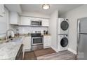 Cozy kitchen featuring stainless steel appliances, granite countertops, and a stackable washer/dryer at 1512 Seigle Ave # 2, Charlotte, NC 28205