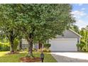 Charming home with mature landscaping, a welcoming front porch, and a two-car garage at 1525 Moss Creek Dr, Harrisburg, NC 28075