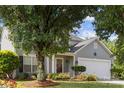 Charming home with mature landscaping, a welcoming front porch, and a two-car garage at 1525 Moss Creek Dr, Harrisburg, NC 28075