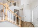 Bright foyer with hardwood floors, staircase with wood banister and white risers, and a two-story ceiling at 16017 Woodcote Dr, Huntersville, NC 28078