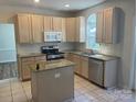 Well-lit kitchen featuring granite countertops, stainless steel appliances, and ample cabinet space for storage at 16017 Woodcote Dr, Huntersville, NC 28078