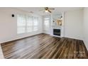 Inviting living room featuring a decorative fireplace, large windows, and hardwood flooring at 16017 Woodcote Dr, Huntersville, NC 28078