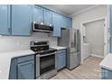 Well-equipped kitchen boasts modern appliances, stylish blue cabinets, and bright subway tile backsplash for easy upkeep at 16610 Amberside E Rd, Cornelius, NC 28031