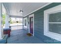 A quaint, covered front porch with a burgundy door and space for seating at 209 W Marsh St, Salisbury, NC 28144
