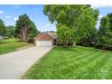 Beautiful brick home with a spacious front yard and long driveway, surrounded by lush greenery at 2315 Perry Rd, Denver, NC 28037
