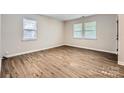 Comfortable bedroom featuring wood-look flooring and two bright windows with blinds at 2424 Pitts Dr, Charlotte, NC 28216