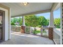 Inviting covered front porch with brick columns and white railing, perfect for relaxing at 2424 Pitts Dr, Charlotte, NC 28216