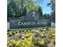 Community sign for Cameron Wood with a pineapple emblem and colorful flower beds at 3133 English Sparrow Ln, Charlotte, NC 28210