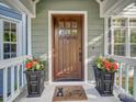 Inviting front entrance with a beautiful wood door, potted plants, and a welcome mat at 3133 English Sparrow Ln, Charlotte, NC 28210