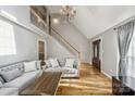 Bright living room with hardwood floors, a grand staircase, and an elegant chandelier at 3223 Rheinwood Ct, Matthews, NC 28105