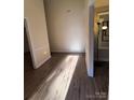 Bright hallway featuring wood-look flooring, white trim, and neutral paint at 5601 Carmel Station Ave, Charlotte, NC 28226