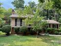 Charming house with a cozy covered porch, surrounded by lush greenery and well-maintained landscaping at 5938 Sharon Rd, Charlotte, NC 28210