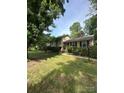 Beautiful home with a covered porch, manicured lawn, and lush greenery, offering a serene setting at 5938 Sharon Rd, Charlotte, NC 28210