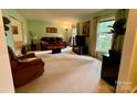 Spacious living room with neutral walls, carpeted floors, and natural light streaming through large windows at 5938 Sharon Rd, Charlotte, NC 28210