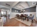 Elegant dining room with tray ceiling, modern chandelier, hardwood floors, and wainscoting at 724 Lagan Ct, Fort Mill, SC 29715