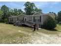 Ranch-style home with beige siding, red shutters, front ramp, and a well-maintained lawn at 7494 Flat Creek Rd, Lancaster, SC 29720