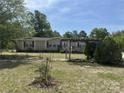 Charming ranch-style home with beige siding, red shutters, a front ramp, and a spacious front yard at 7494 Flat Creek Rd, Lancaster, SC 29720