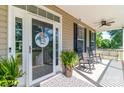 Cozy porch featuring rocking chairs, a decorative door, potted plants, and a ceiling fan for comfort at 945 Songbird St, Lancaster, SC 29720