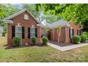 Attractive red brick home featuring manicured landscaping, and a welcoming walkway to the front door at 10011 Spring Park Dr, Charlotte, NC 28269