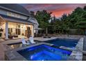 Backyard with a luxurious pool, integrated hot tub, outdoor fireplace, and lounge seating for ultimate relaxation at 106 Thunder Hill Rd, Mooresville, NC 28117