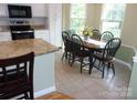 Well-lit kitchen and breakfast area featuring white cabinets, granite countertops, and stainless appliances at 109 Gatwick Ct, Statesville, NC 28677