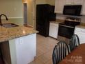 Bright kitchen featuring granite countertops, stainless steel appliances, and white cabinetry at 109 Gatwick Ct, Statesville, NC 28677