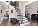 Elegant foyer with hardwood floors, staircase with wrought iron railings, and paneled walls at 1098 Matchstick Sw Pl, Concord, NC 28025