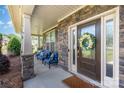 Inviting front porch with comfortable seating, stone accents, and decorative floral wreath at 1098 Matchstick Sw Pl, Concord, NC 28025