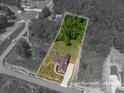 Aerial view of the property showcasing the home, lot lines, and surrounding landscape at 115 Woodward Way, Iron Station, NC 28080