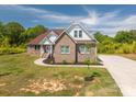 A well-maintained brick home with a lush lawn and a long driveway at 115 Woodward Way, Iron Station, NC 28080