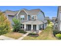 Attractive two-story home showcasing stone details, a covered porch, and a well-maintained landscape at 13332 Caite Ridge Rd, Davidson, NC 28036