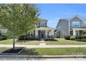 Charming two-story home featuring a covered porch, stone accents, and a well-manicured front lawn at 13332 Caite Ridge Rd, Davidson, NC 28036