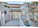 Close-up of front entrance, featuring glass door and wood deck at 13932 Queens Harbor Rd, Charlotte, NC 28278