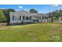 Inviting single-story house with traditional siding, dark shutters, manicured lawn and an adjacent carport at 159 Old Home Pl, China Grove, NC 28023